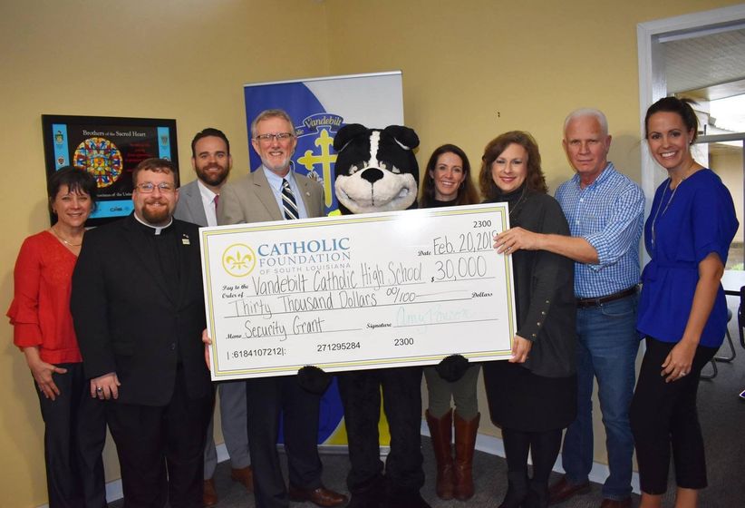 Representatives of the Diocese of Houma-Thibodaux and Vandebilt Catholic High School are pictured during the ceremony awarding $30,000 to Vandebilt for school security improvements. Pictured left-to-right with the Terrier mascot are April LeBouef, Fr.